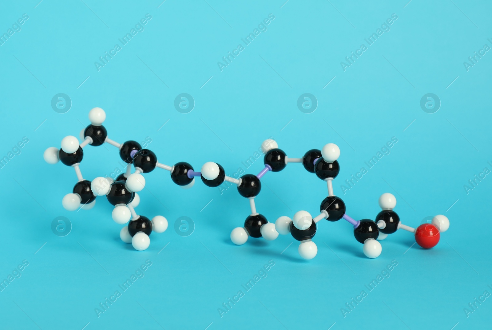 Photo of Molecule of retinol (vitamin A) on light blue background. Chemical model