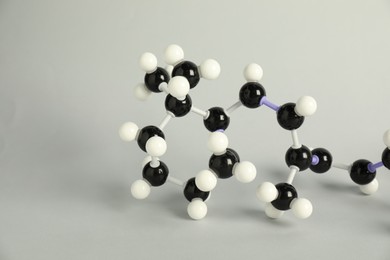 Photo of Molecule of retinol (vitamin A) on light grey background, closeup. Chemical model