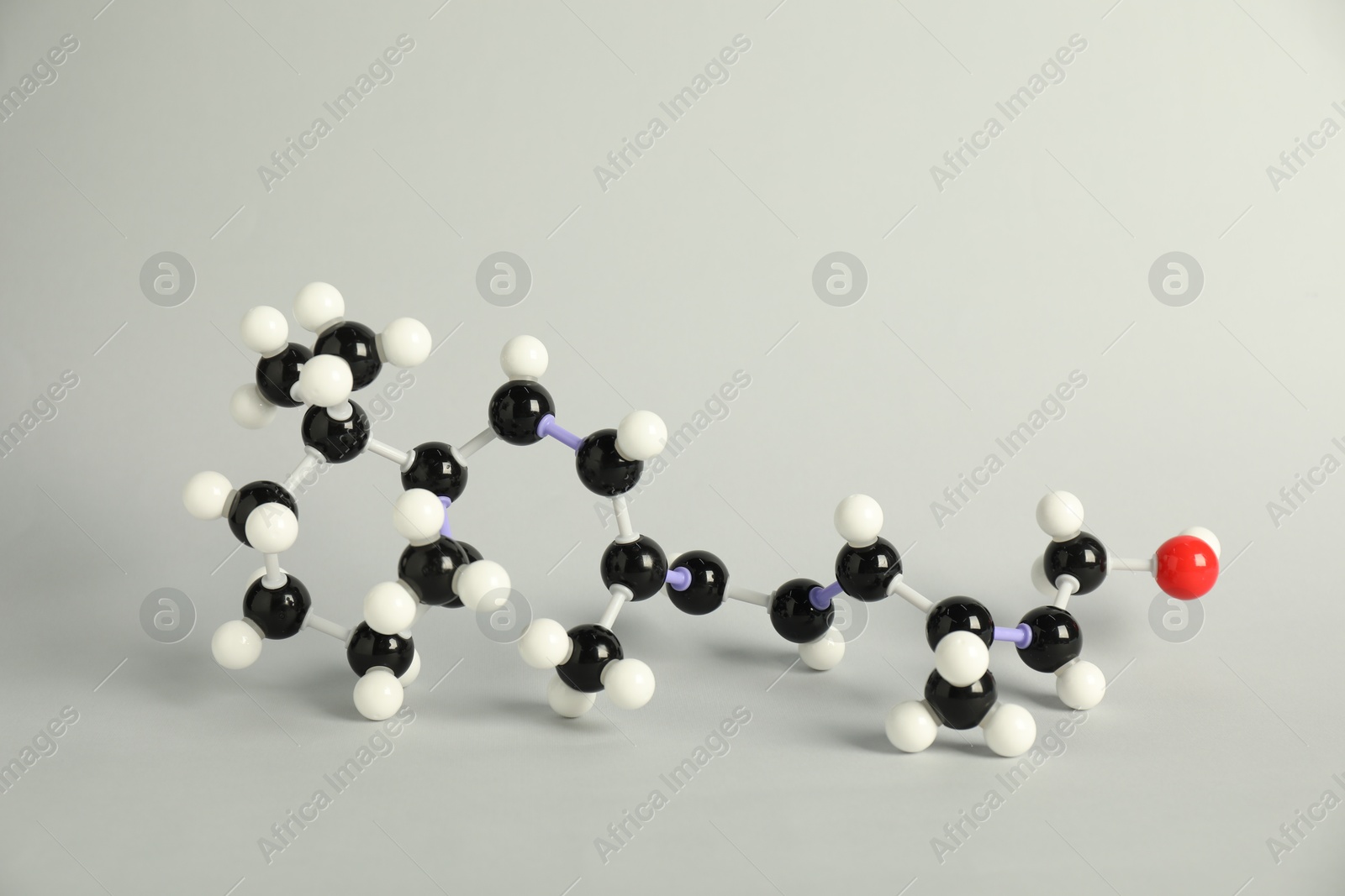 Photo of Molecule of retinol (vitamin A) on light grey background. Chemical model