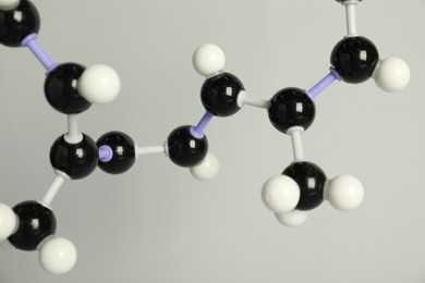 Photo of Molecule of retinol (vitamin A) on light grey background, closeup. Chemical model