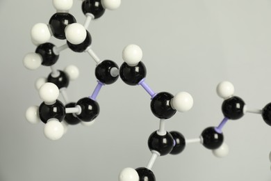 Photo of Molecule of retinol (vitamin A) on light grey background, closeup. Chemical model