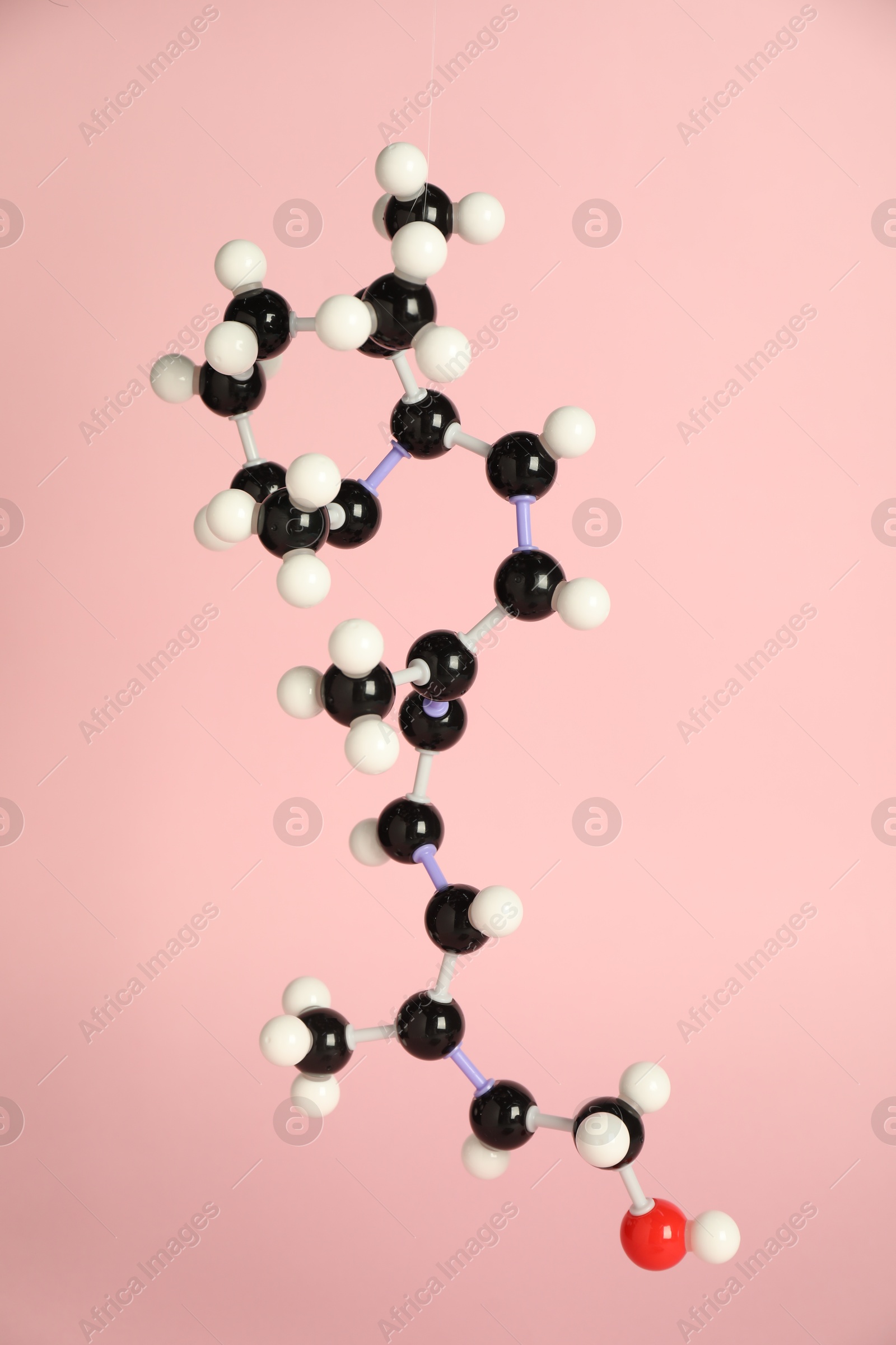 Photo of Molecule of retinol (vitamin A) on pink background. Chemical model