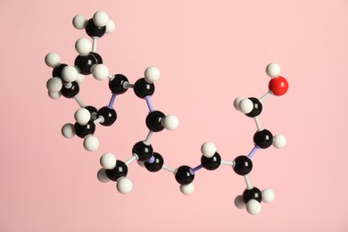 Photo of Molecule of retinol (vitamin A) on pink background. Chemical model