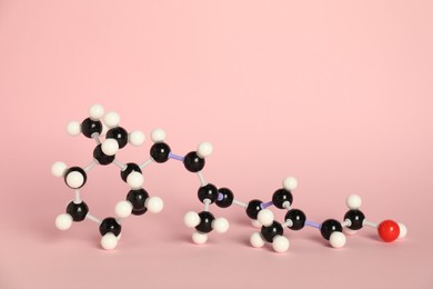 Photo of Molecule of retinol (vitamin A) on pink background. Chemical model