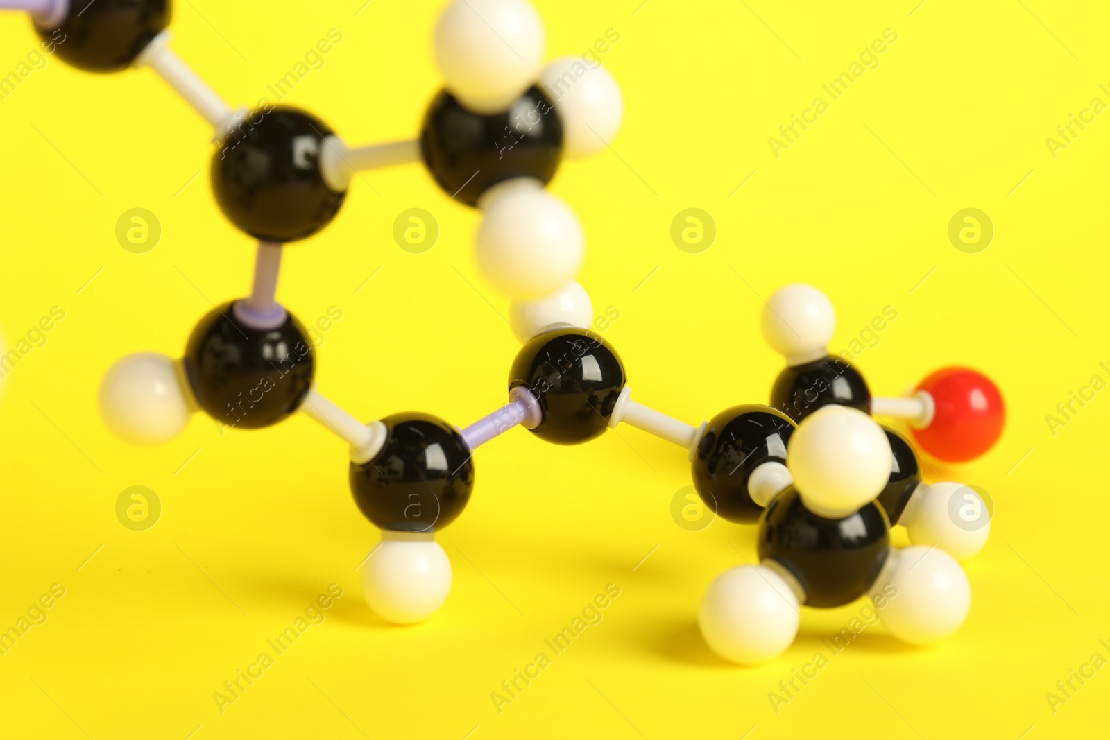 Photo of Molecule of retinol (vitamin A) on yellow background, closeup. Chemical model