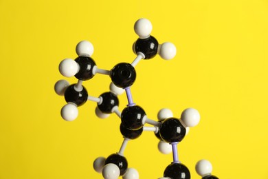 Photo of Molecule of retinol (vitamin A) on yellow background, closeup. Chemical model