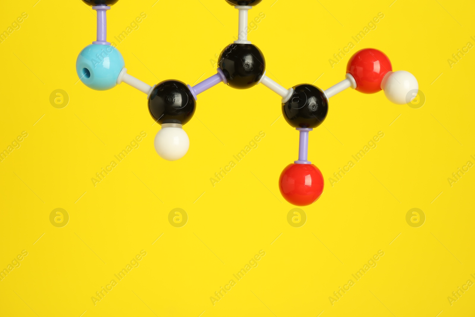 Photo of Molecule of niacin (vitamin B3) on yellow background, closeup and space for text. Chemical model