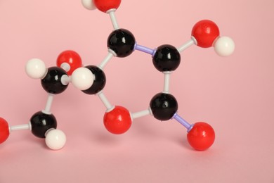 Photo of Molecule of vitamin C on pink background, closeup. Chemical model