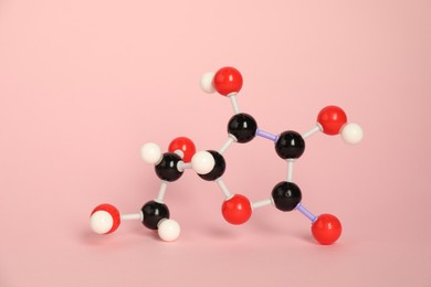 Photo of Molecule of vitamin C on pink background. Chemical model