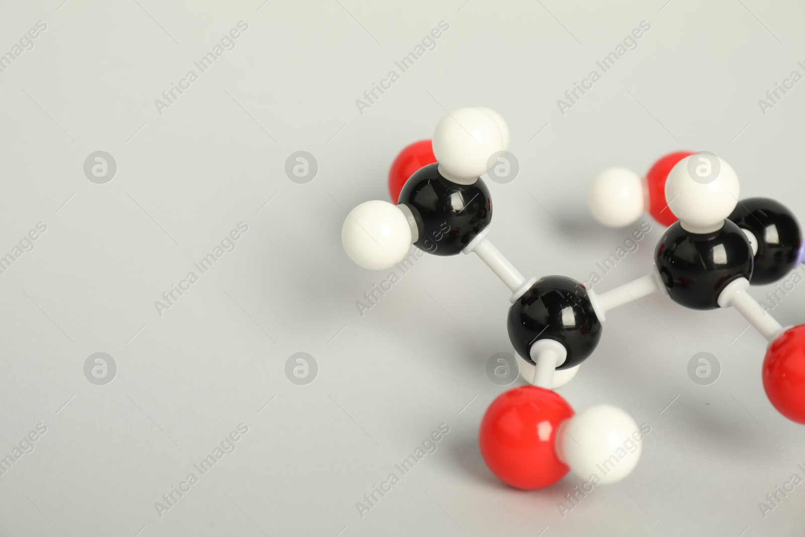 Photo of Molecule of vitamin C on light grey background, closeup and space for text. Chemical model