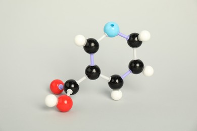 Photo of Molecule of niacin (vitamin B3) on light grey background. Chemical model