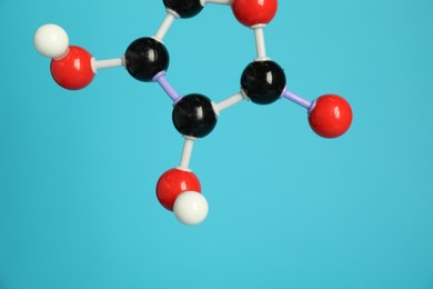 Photo of Molecule of vitamin C on light blue background, closeup. Chemical model