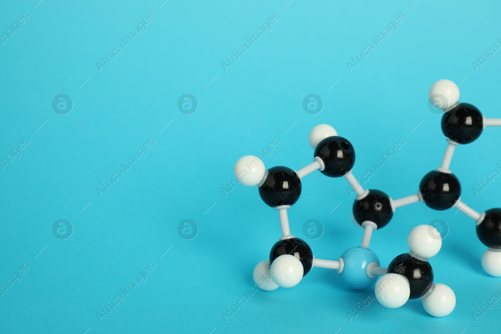 Photo of Chemical model of molecule on light blue background, closeup. Space for text