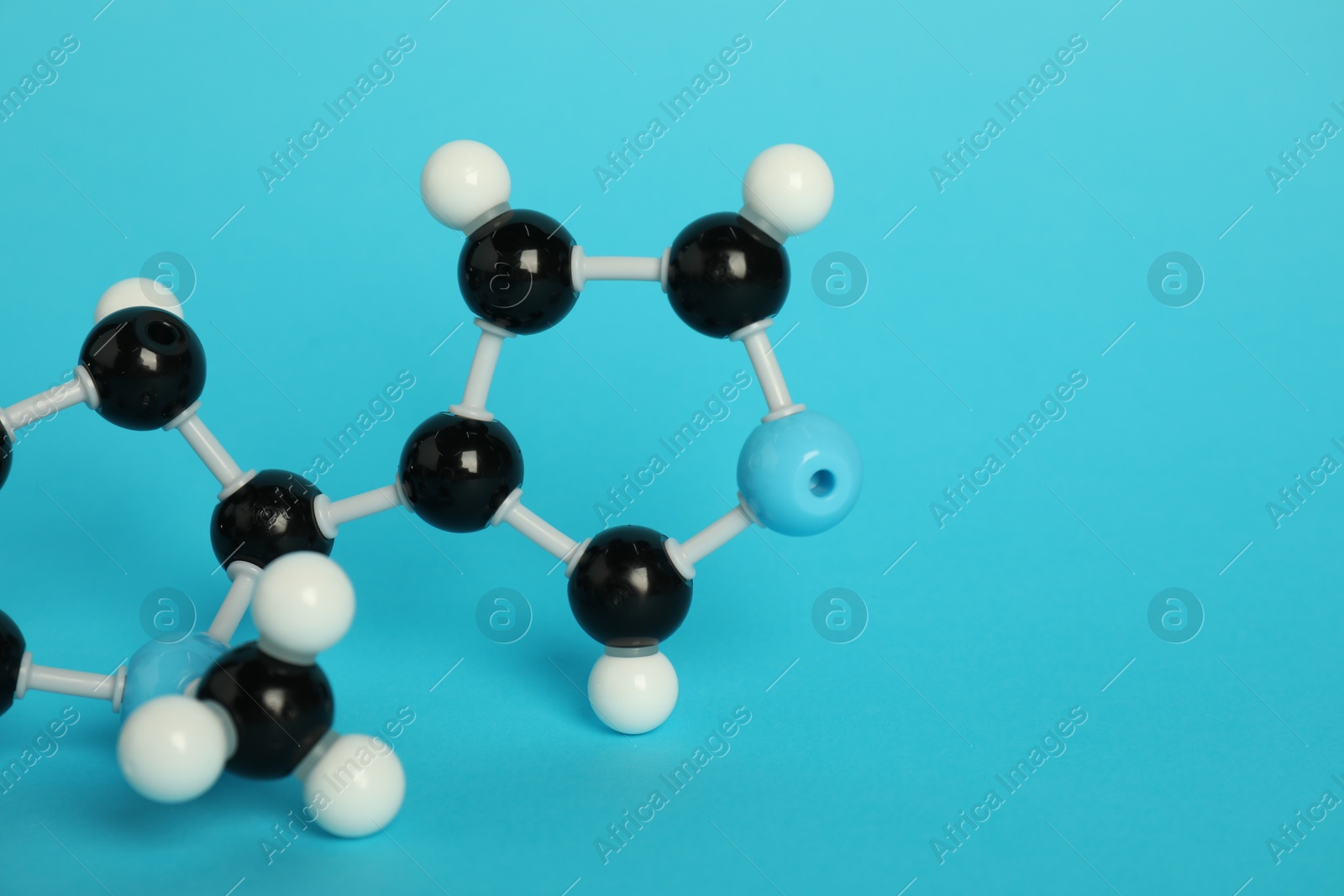 Photo of Chemical model of molecule on light blue background, closeup. Space for text