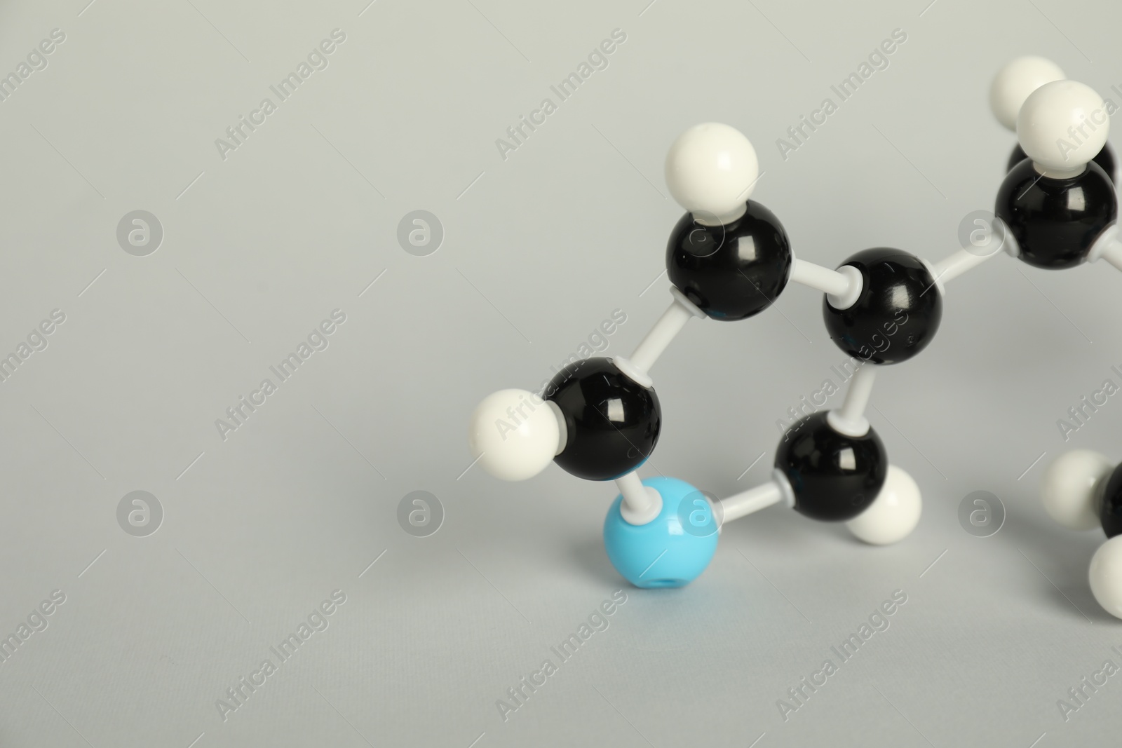 Photo of Chemical model of molecule on light grey background, closeup. Space for text