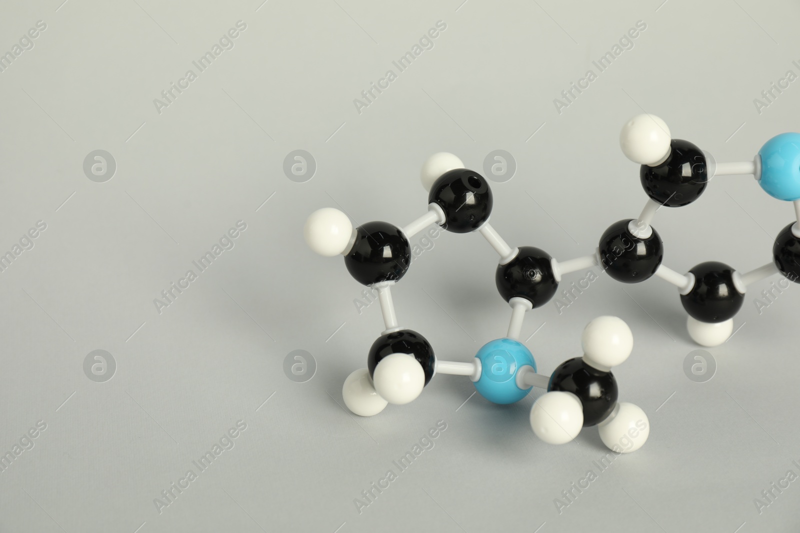 Photo of Chemical model of molecule on light grey background, closeup. Space for text