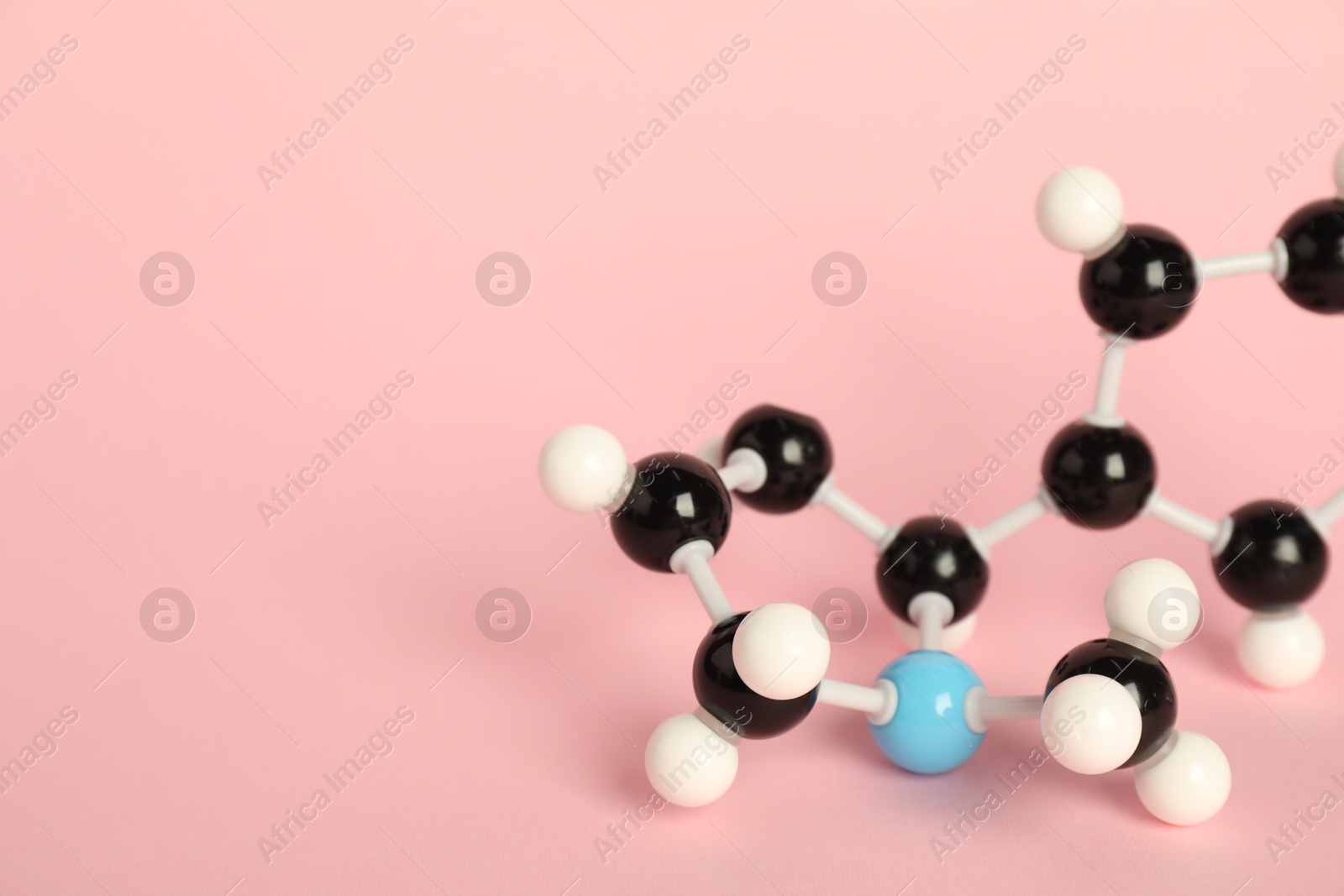 Photo of Chemical model of molecule on pink background, closeup. Space for text