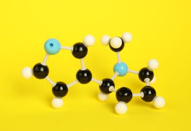 Photo of Chemical model of molecule on yellow background