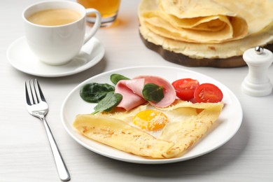 Photo of Delicious crepe with egg, ham and parmesan cheese served on white wooden table, closeup