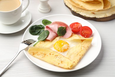 Photo of Delicious crepe with egg, ham and parmesan cheese served on white wooden table, closeup