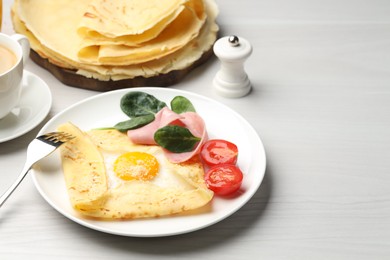 Photo of Delicious crepe with egg, ham and parmesan cheese served on white wooden table, space for text