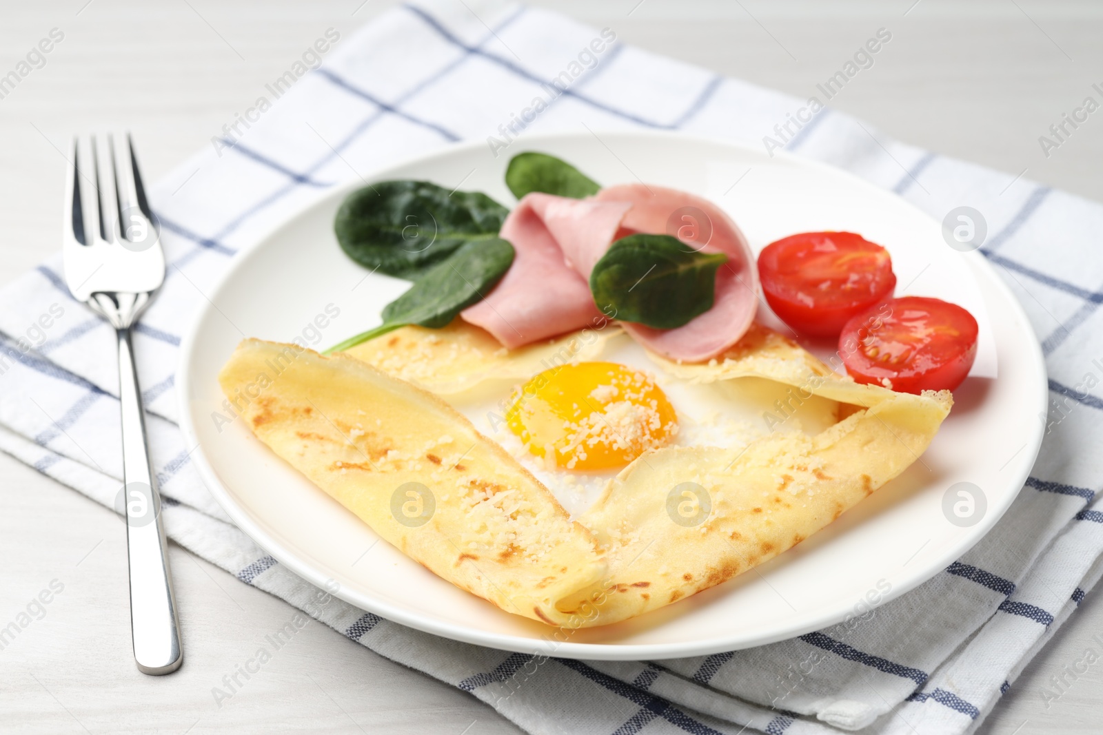 Photo of Delicious crepe with egg, ham and parmesan cheese served on white table, closeup