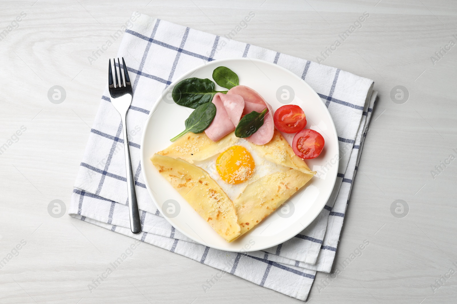 Photo of Delicious crepe with egg, ham and parmesan cheese served on white wooden table, flat lay