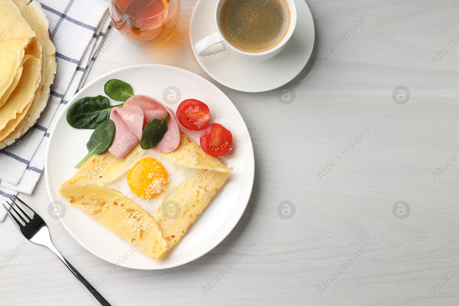 Photo of Delicious crepe with egg, ham and parmesan cheese served on light wooden table, flat lay. Space for text