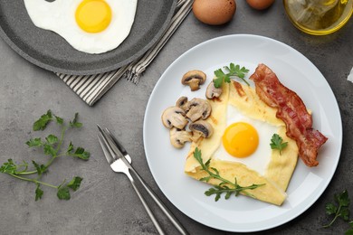 Photo of Delicious crepe bretonne with bacon, mushrooms and arugula served on grey table, flat lay