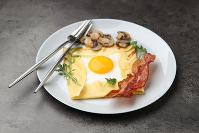 Photo of Delicious crepe bretonne with bacon, mushrooms and arugula served on grey table, closeup