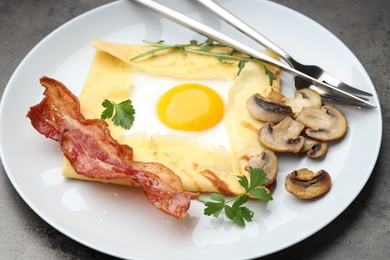 Photo of Delicious crepe bretonne with bacon, mushrooms and arugula served on grey table, closeup