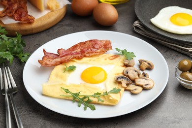 Photo of Delicious crepe bretonne with bacon, mushrooms and arugula served on grey table, closeup