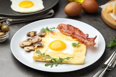 Photo of Delicious crepe bretonne with bacon, mushrooms and arugula served on grey table, closeup