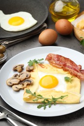 Photo of Delicious crepe bretonne with bacon, mushrooms and arugula served on grey table, closeup