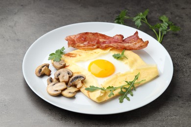 Photo of Delicious crepe bretonne with bacon, mushrooms and arugula on grey table, closeup