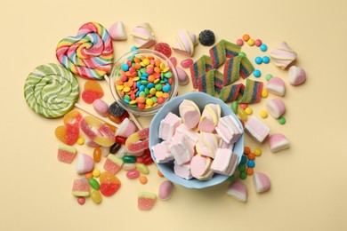 Photo of Different delicious candies and marshmallows on beige background, flat lay