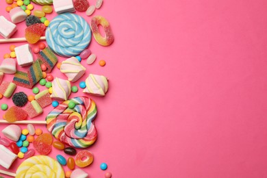 Photo of Different delicious candies and marshmallows on pink background, flat lay. Space for text