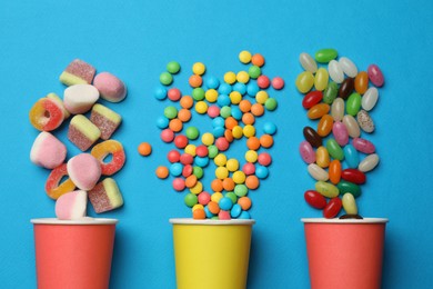 Photo of Different delicious candies on blue background, flat lay