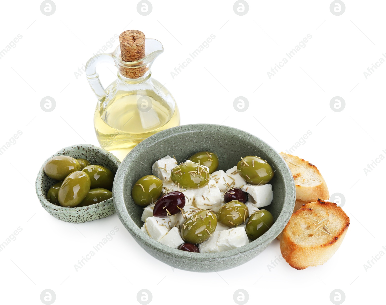 Photo of Marinated olives, feta cheese, bread pieces and oil isolated on white