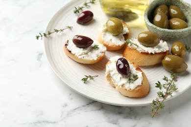 Photo of Delicious sandwiches with cream cheese and marinated olives on white marble table