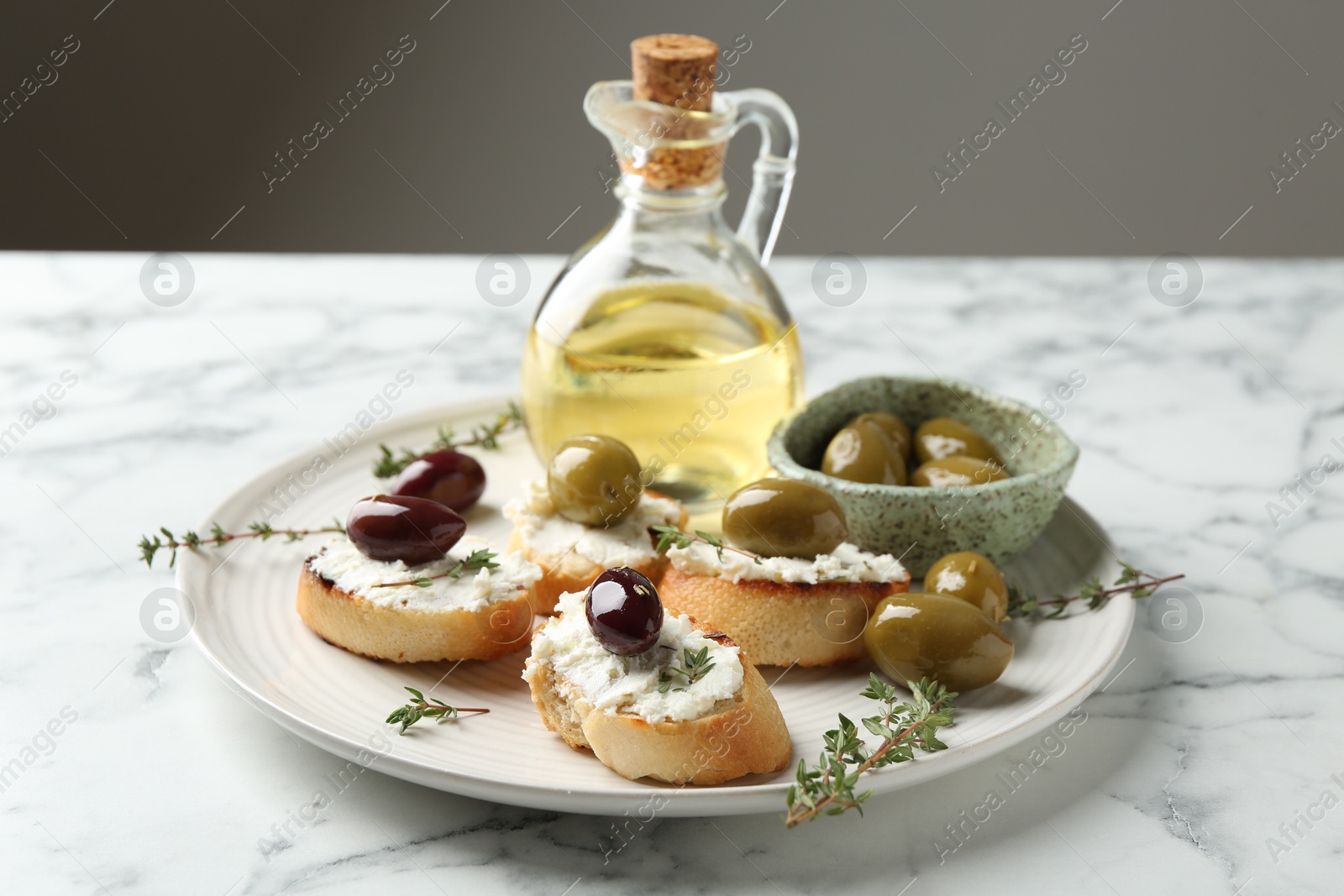 Photo of Delicious sandwiches with cream cheese and marinated olives on white marble table