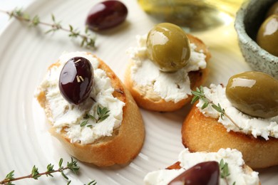 Photo of Delicious sandwiches with cream cheese and marinated olives on light table