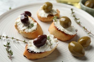 Photo of Delicious sandwiches with cream cheese and marinated olives on light table