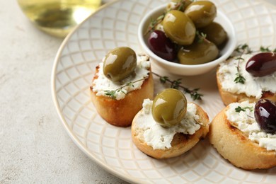 Photo of Delicious sandwiches with cream cheese and marinated olives on light table