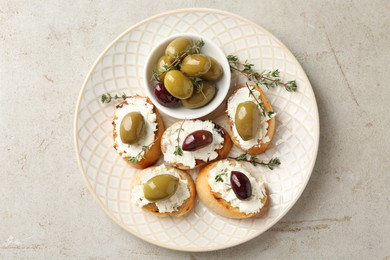 Photo of Delicious sandwiches with cream cheese and marinated olives on light table