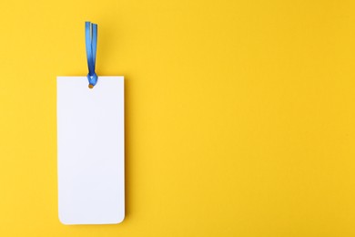 Photo of One paper bookmark on yellow background, top view. Space for text