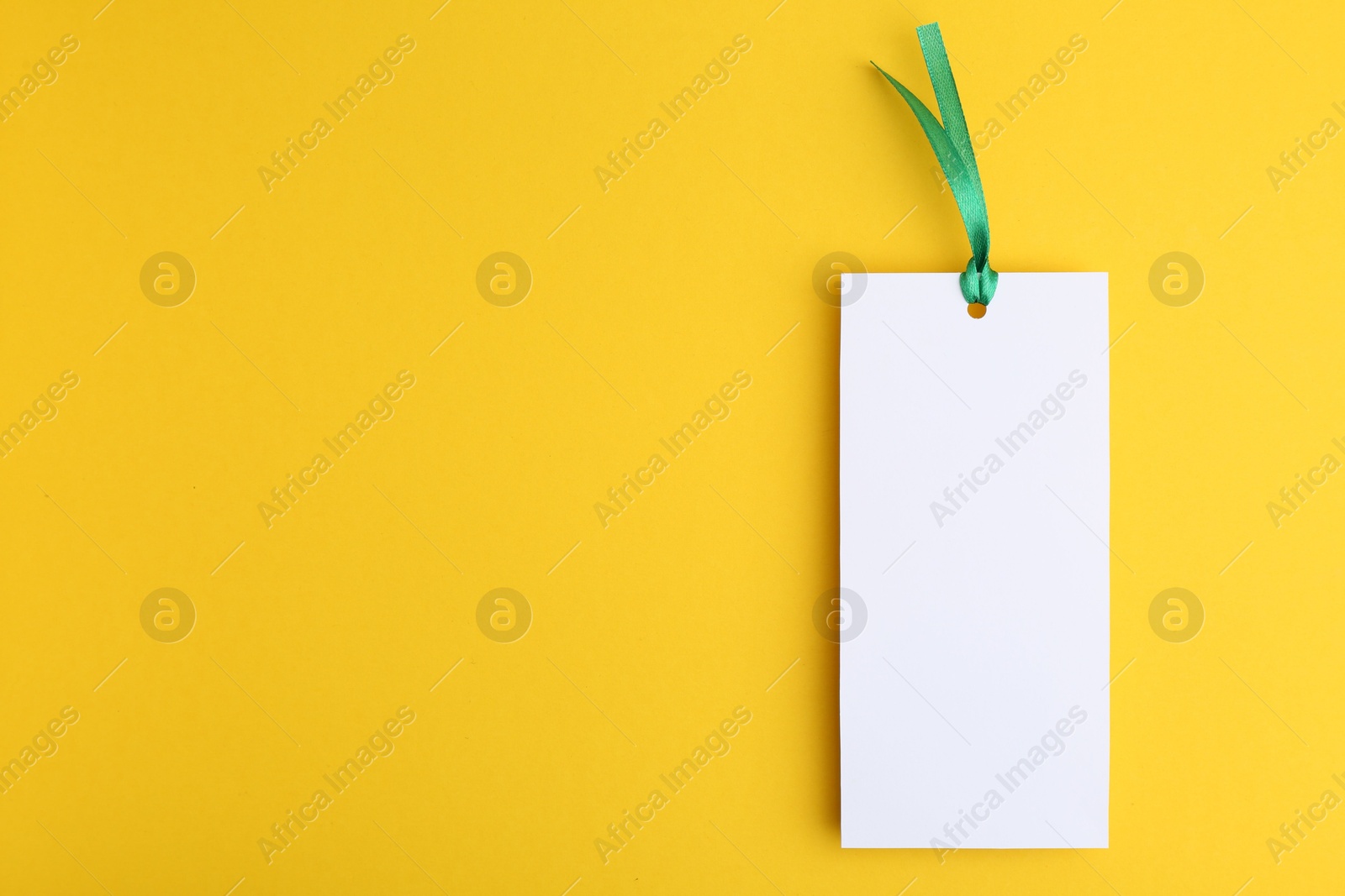 Photo of One paper bookmark on yellow background, top view. Space for text