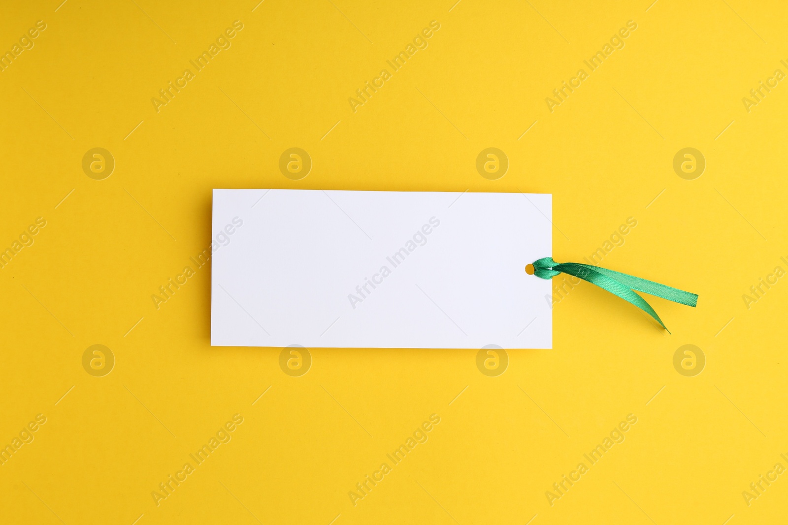 Photo of One paper bookmark on yellow background, top view