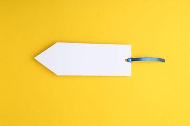 Photo of One paper bookmark on yellow background, top view