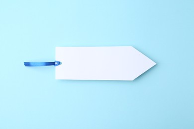 Photo of One paper bookmark on light blue background, top view